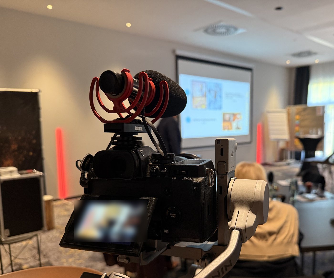 Kamera mit Gimbal und Mikrofon filmt einen Vortrag bei einer Firmenveranstaltung